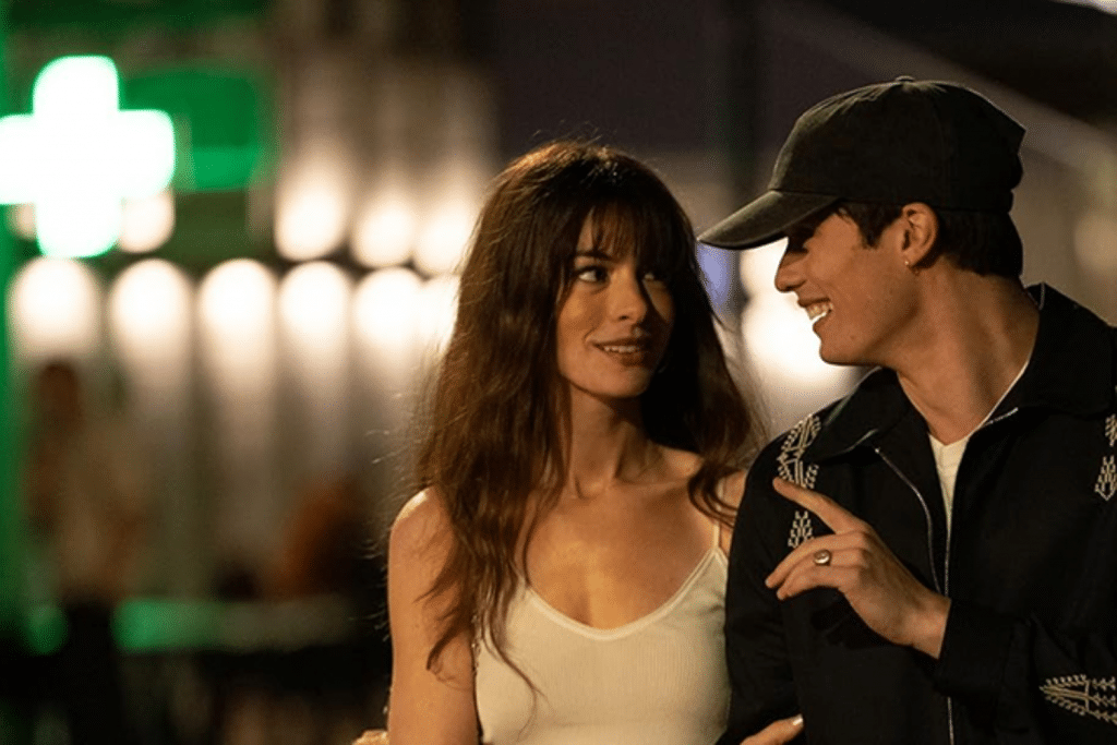 Một đôi nam nữ trẻ tuổi nhìn nhau mỉm cười hạnh phúc giữa phố đêm lung linh