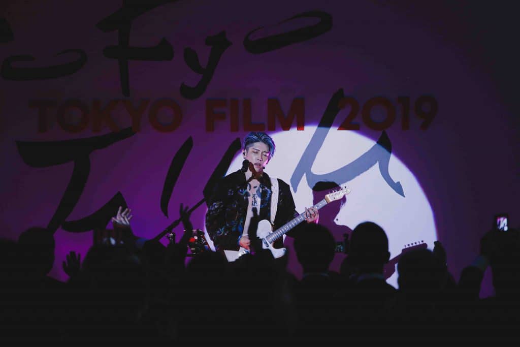 Nghệ sĩ biểu diễn guitar trên sân khấu tại Tokyo Film 2019 với phông nền ánh sáng tím