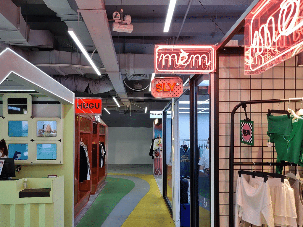 A brightly lit boutique displays clothing racks and neon signs
