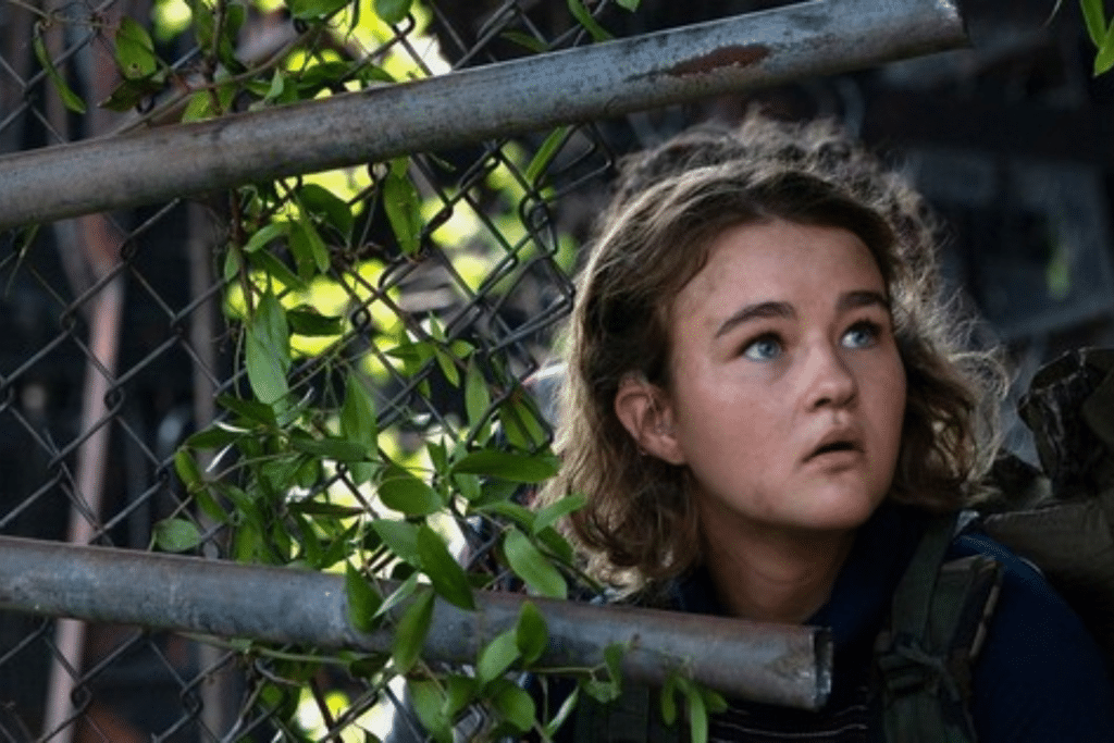 Cô bé nhìn lên với vẻ lo lắng qua hàng rào cây xanh