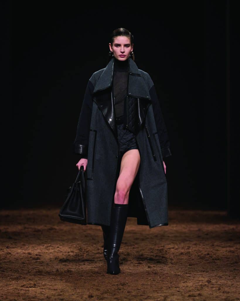 Người mẫu trình diễn áo khoác dài đen và quần short trên sàn diễn thời trang Hermès Thu Đông 2025