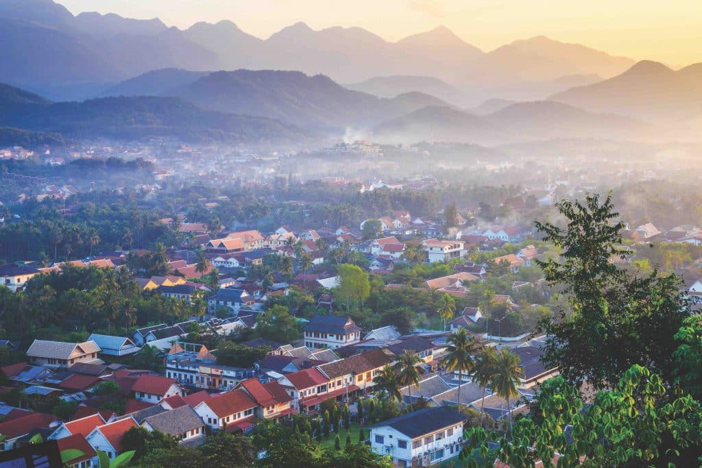 A town nestled among mountains is bathed in warm morning light