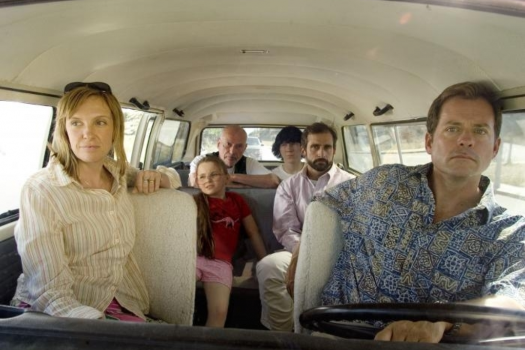 Một gia đình ngồi trong xe ô tô với biểu cảm đa dạng nhìn thẳng vào ống kính