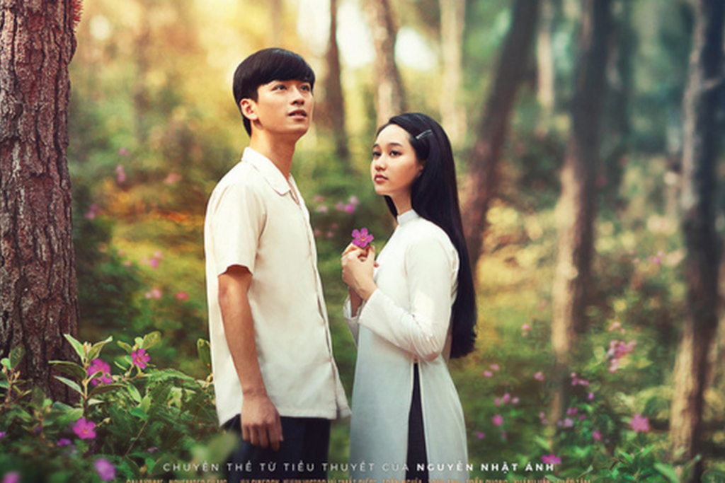 Cặp đôi trẻ nhìn nhau giữa khung cảnh rừng xanh mướt với hoa dại