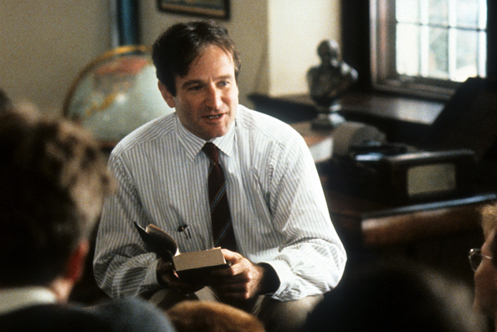 Giáo viên truyền cảm hứng cầm sách nói chuyện với học sinh trong lớp học