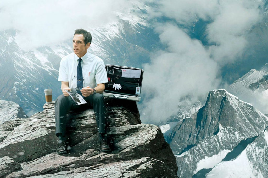 Người đàn ông lịch sự ngồi trên vách đá cao với chiếc vali mở và tách cà phê