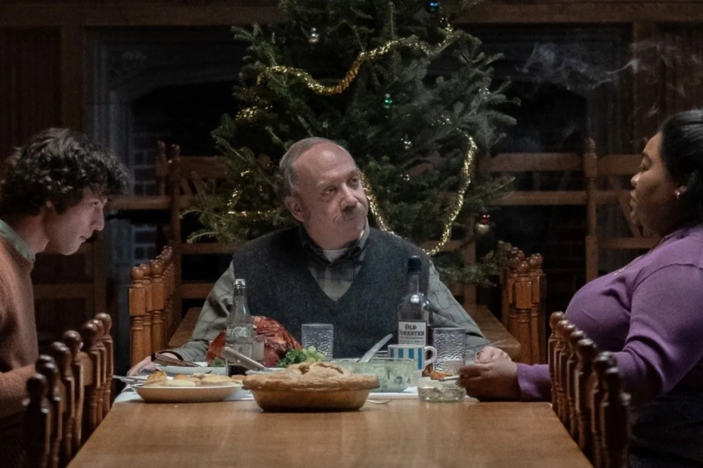 Ba người ngồi ăn tối quanh bàn gỗ trong căn phòng có cây thông Noel